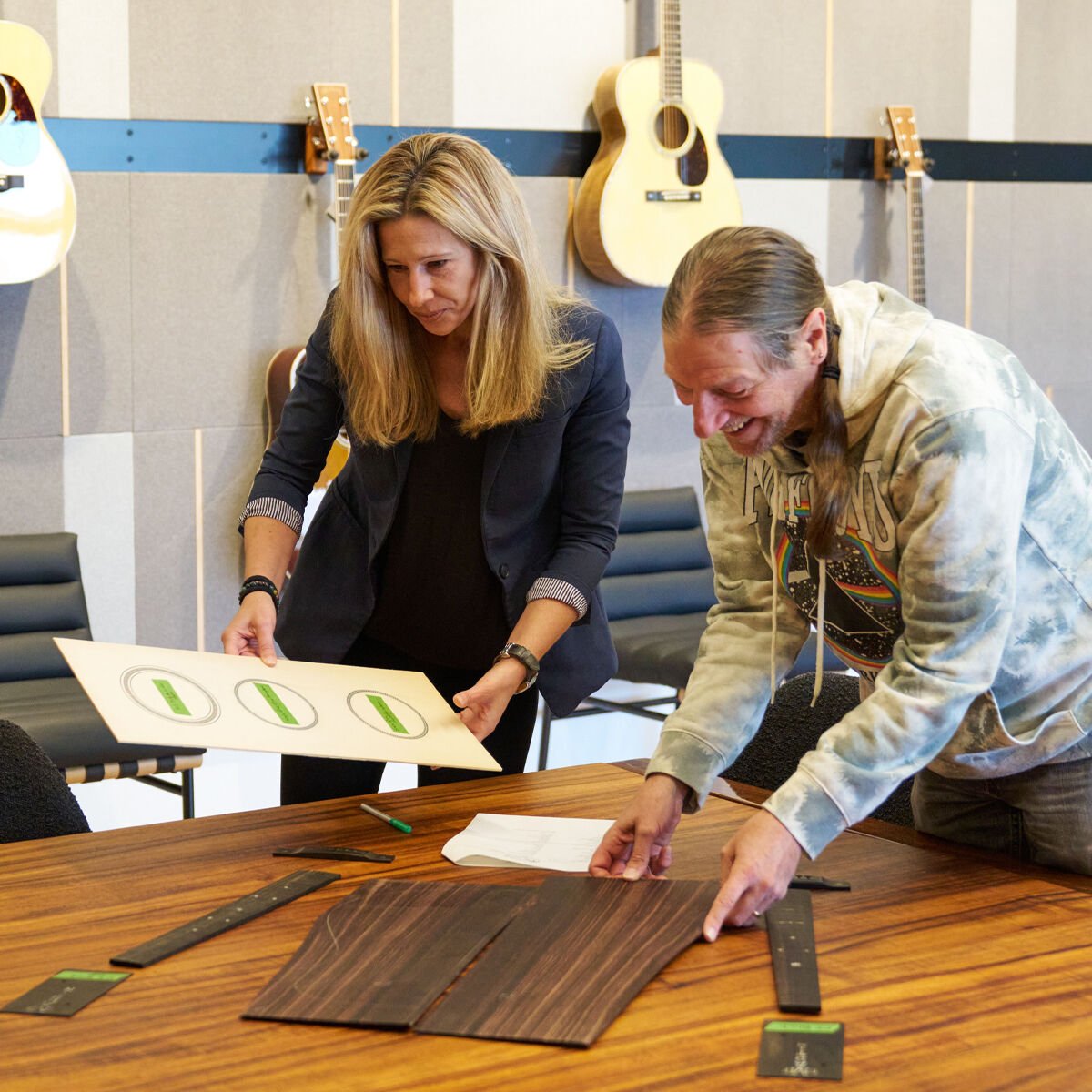 A man and a woman looking at wood samples on a table